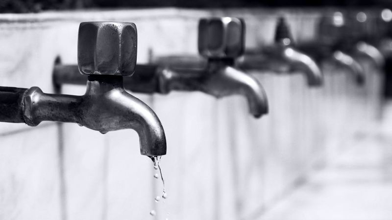 Several water taps. Water flows out of the front one.