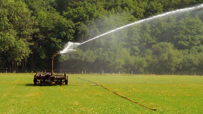 Een weiland dat wordt gesproeid met water.