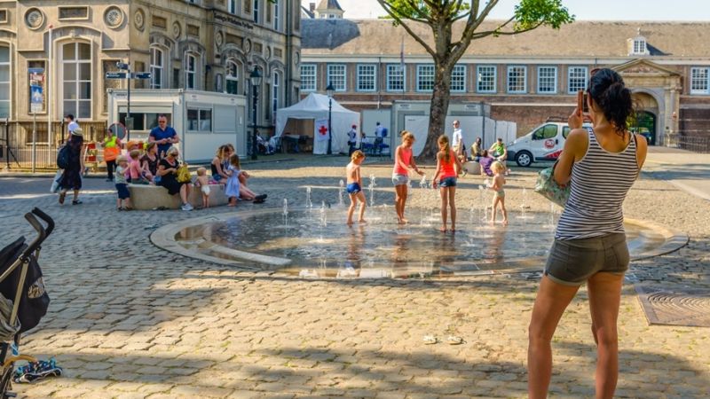 Children playing under a fountain in summer.