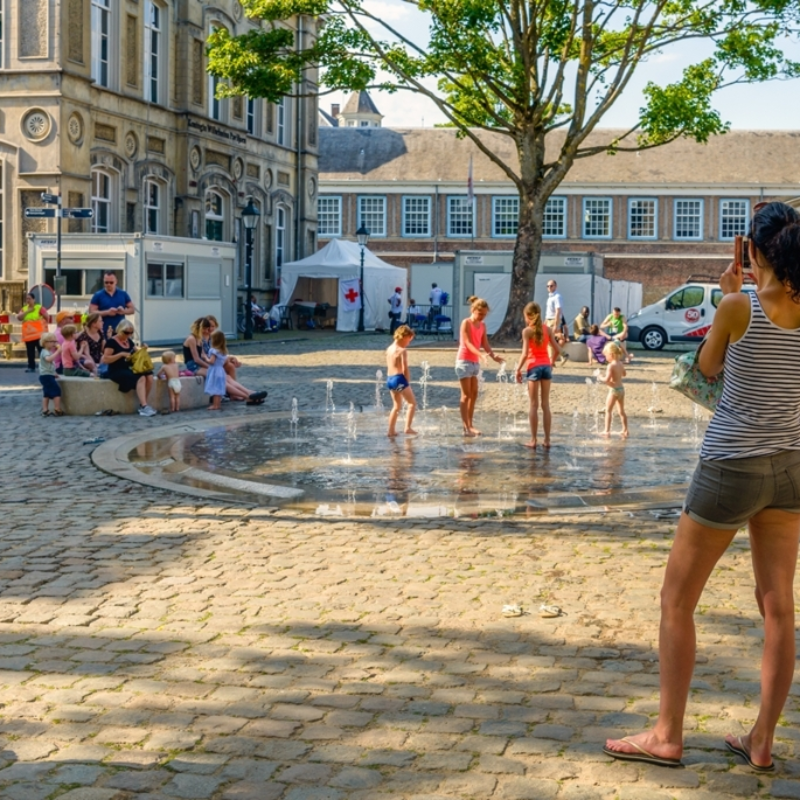 Kinderen die spelen onder een fontein in de zomer.