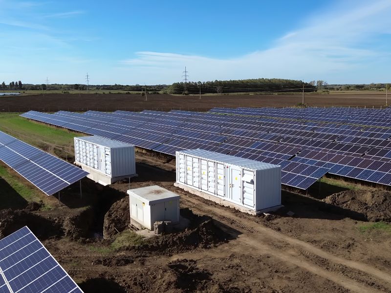 Field with solar panels and energy storage