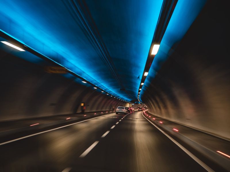 Some cars driving through a tunnel.