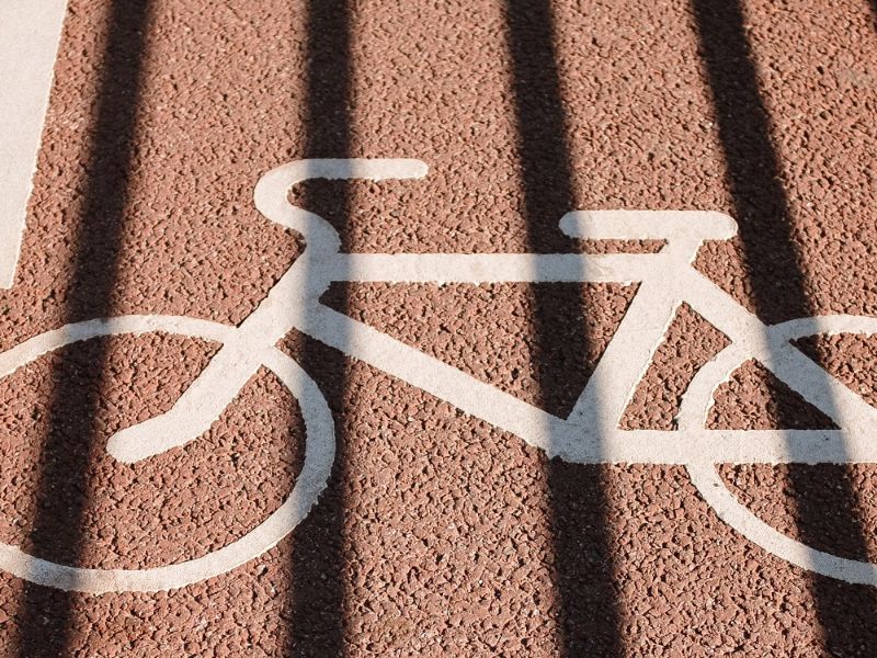 A white signed bicycle on the road.