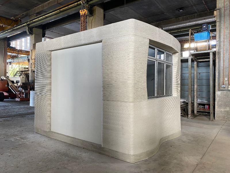 Een foto van een deel van een woning. De woning is gemaakt met een 3D betonprinter.