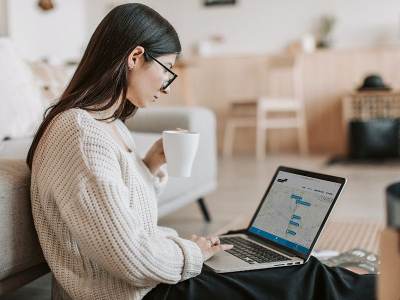 A woman with her laptop on her lap. She is looking at her screen which shows an YourView environment.