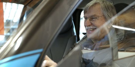 A smiling man sits in the simulator.